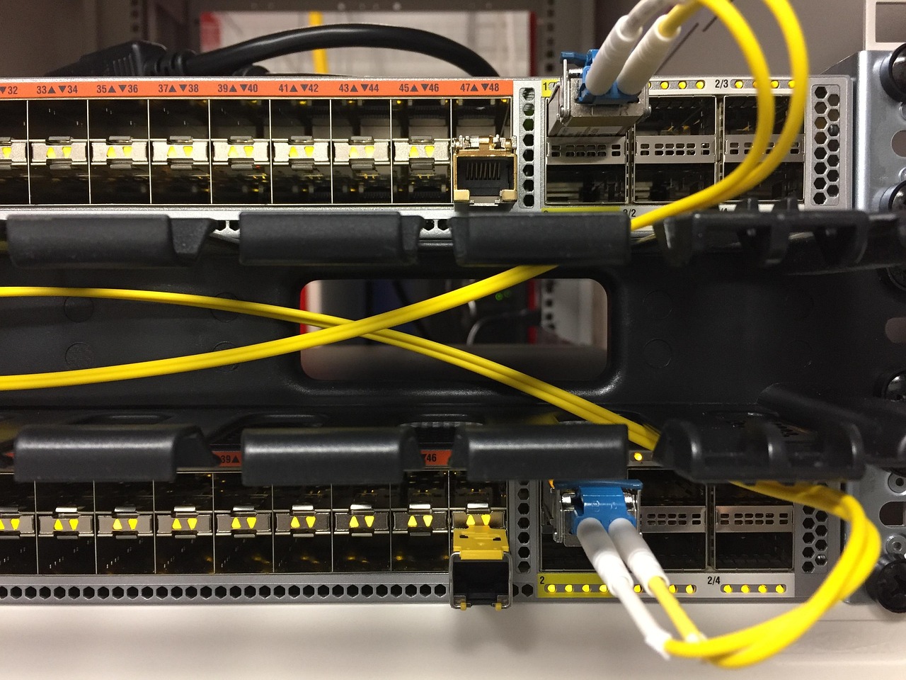 A network switch with fibre patch cables in a data centre.