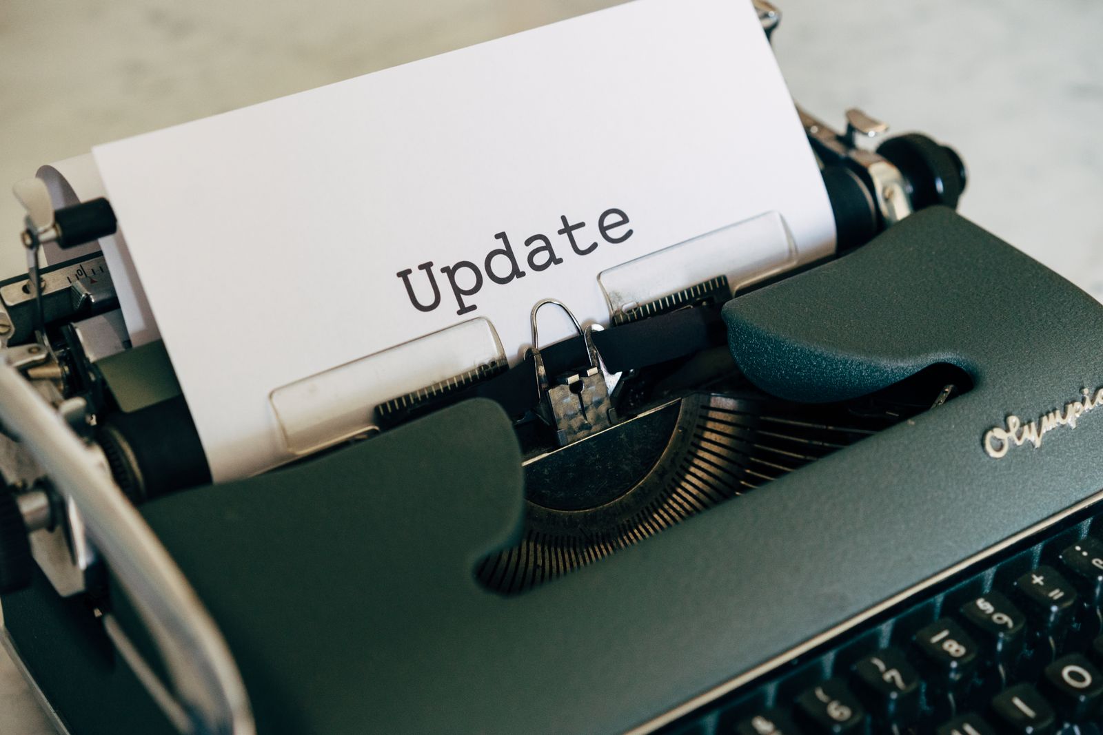 Una máquina de escribir con una hoja que dice Update. Un changelog es un registro escrito de lo que cambió en cada versión.