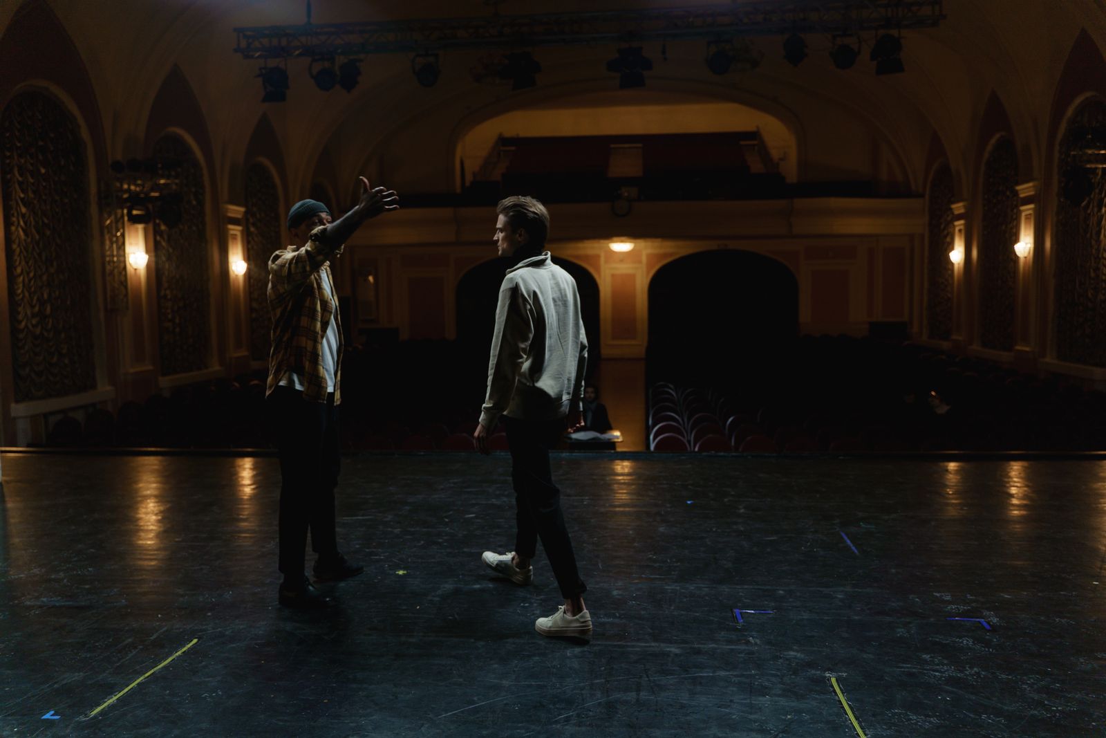 Deux personnes répètent sur la scène d'un théâtre vide, des marques de ruban coloré au sol et une seule personne qui regarde depuis la salle. Une release candidate est cette répétition : tout est en place, et quelqu'un prend encore des notes.