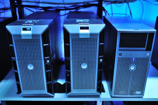 Drei Tower-Server in einem Regal, blau beleuchtet.